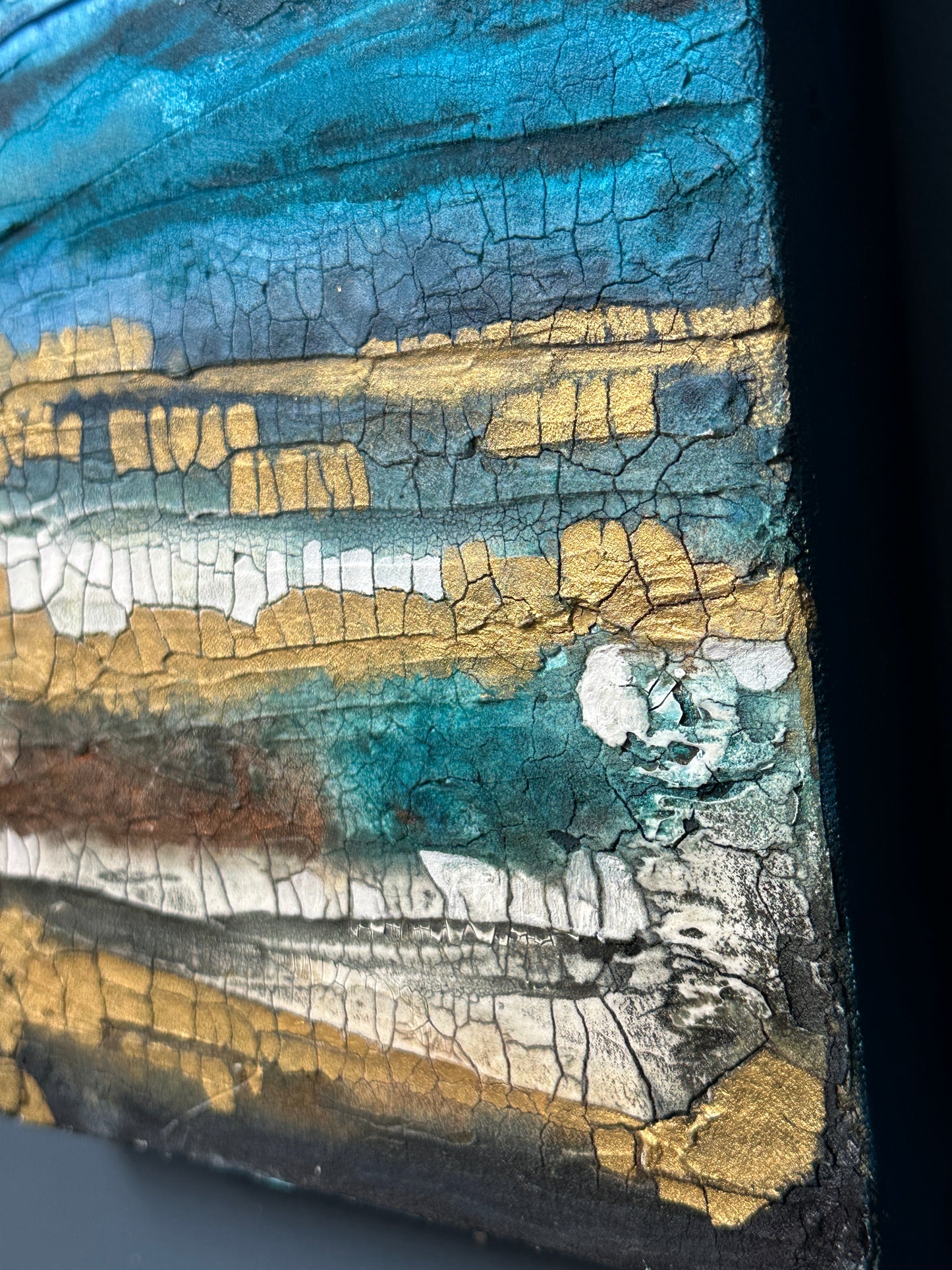 Close-up of a textured surface with blue, gold, and white colors