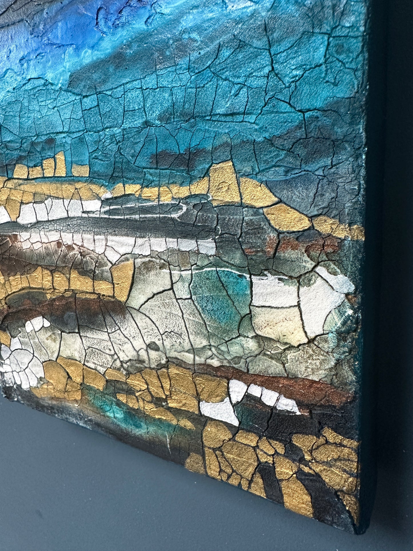 Close-up of a textured surface with blue, gold, and white colors