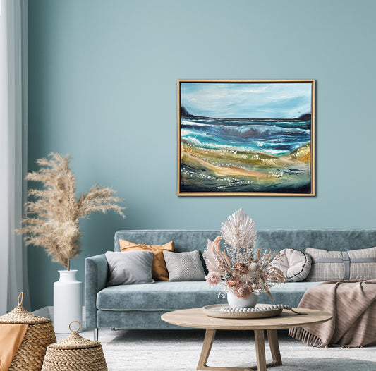 Living room with a gray sofa, decorative pillows, and a painting of a landscape on the wall.