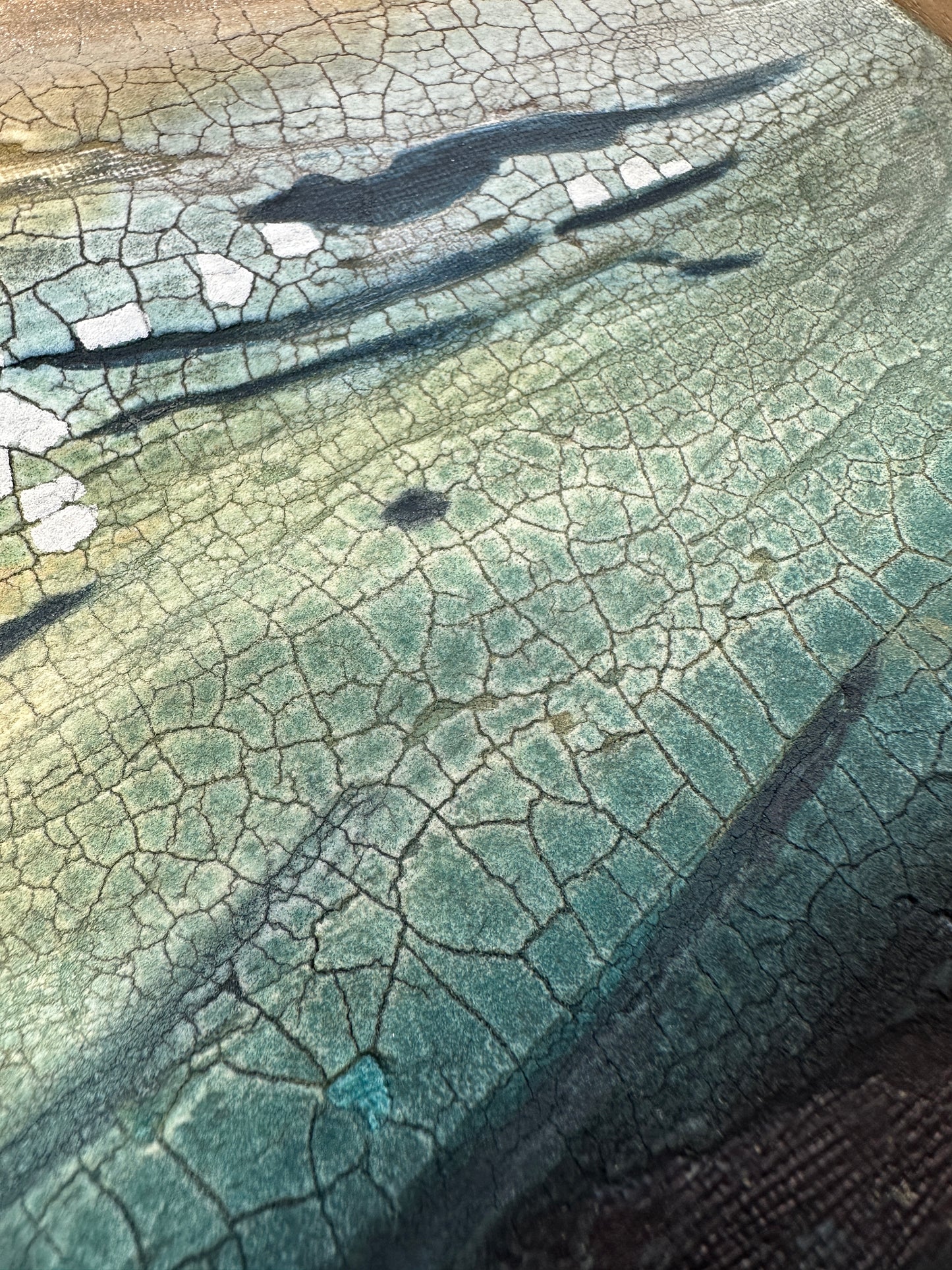 Close-up of a textured painting with a greenish blue tint